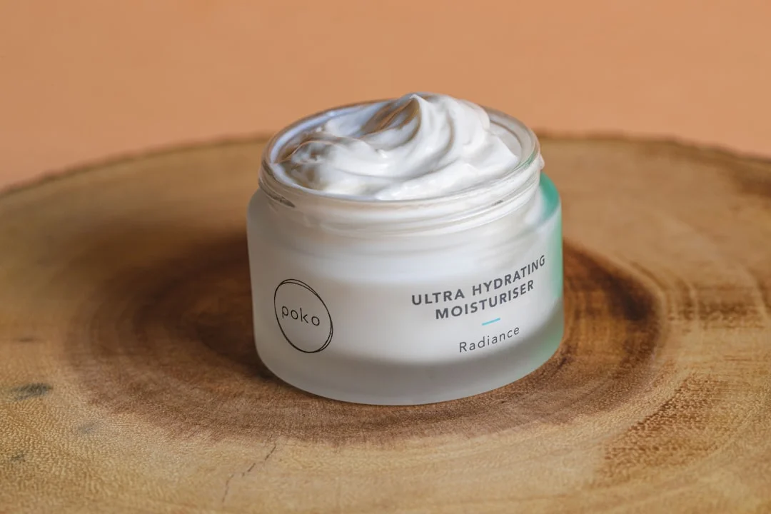 A flat-lay of three clean moisturizer jars at different price points — a drugstore tube, a mid-range botanical cream, and a small-batch luxury pot — arranged on a marble surface beside a printed INCI label